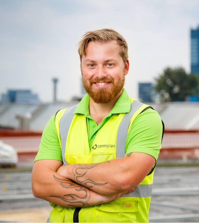 trotse zonneplan monteur op grootste zonnepanelen dak van nederland