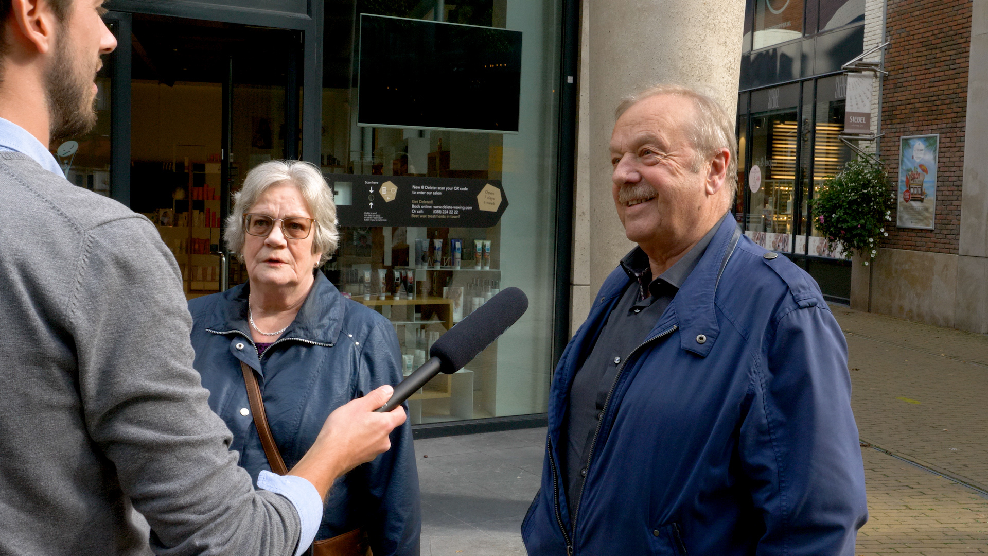 Mensen op straat die worden geïnterviewd door Zonneplan over het onderwerp duurzaamheid