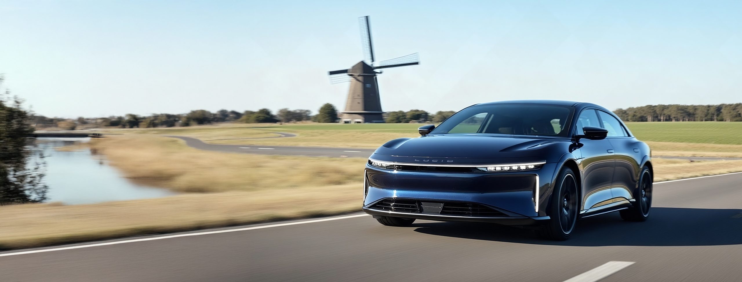 Lucid Air rijdt door de Nederlandse natuur. Onderweg naar werk waar de Lucid aan de laadpaal wordt gezet om opgeladen te worden.