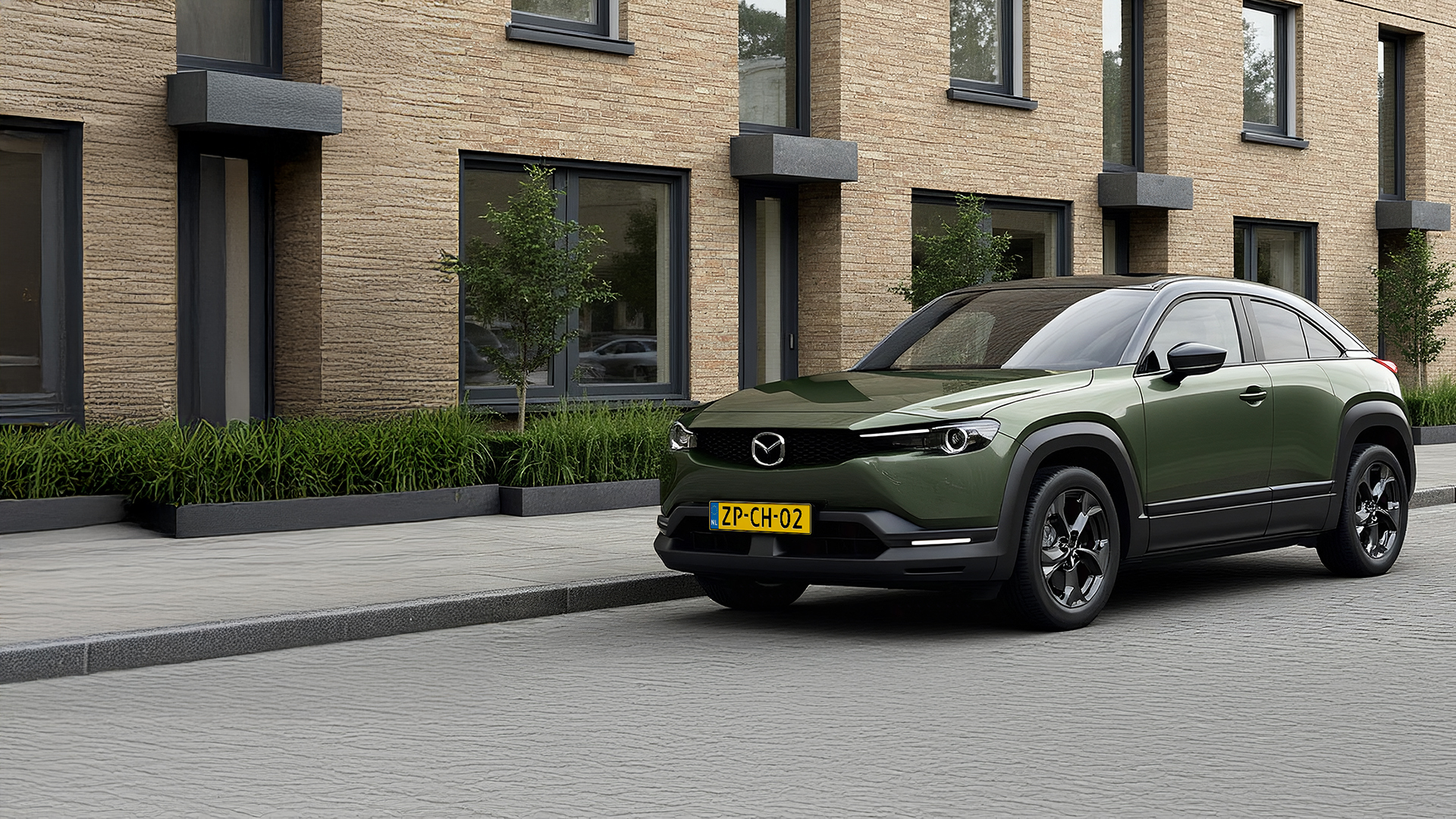 Mazda MX-30 staat geparkeerd voor een huis. De auto staat op te laden aan de laadpaal.
