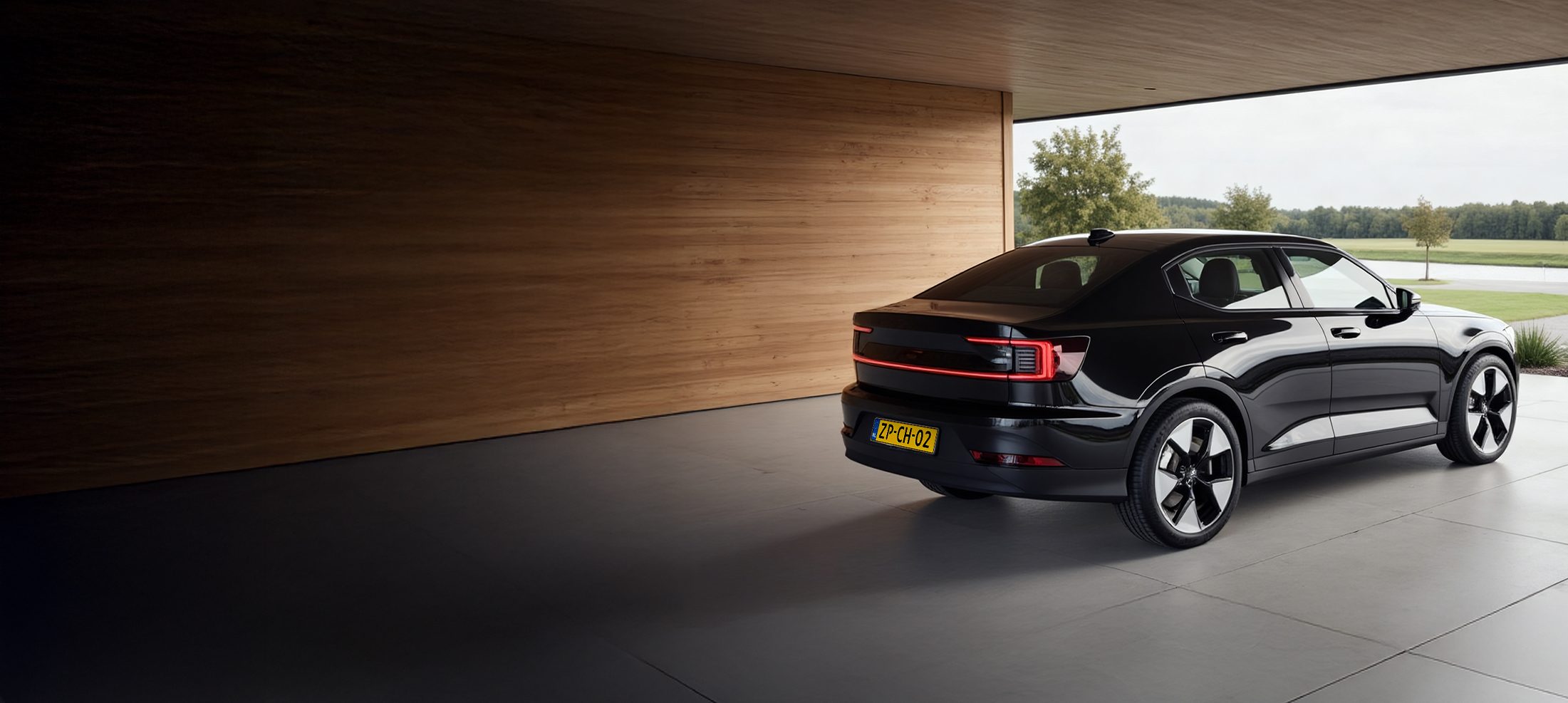 Een Polestar 2 geparkeerd onder een carport met een laadpaal.