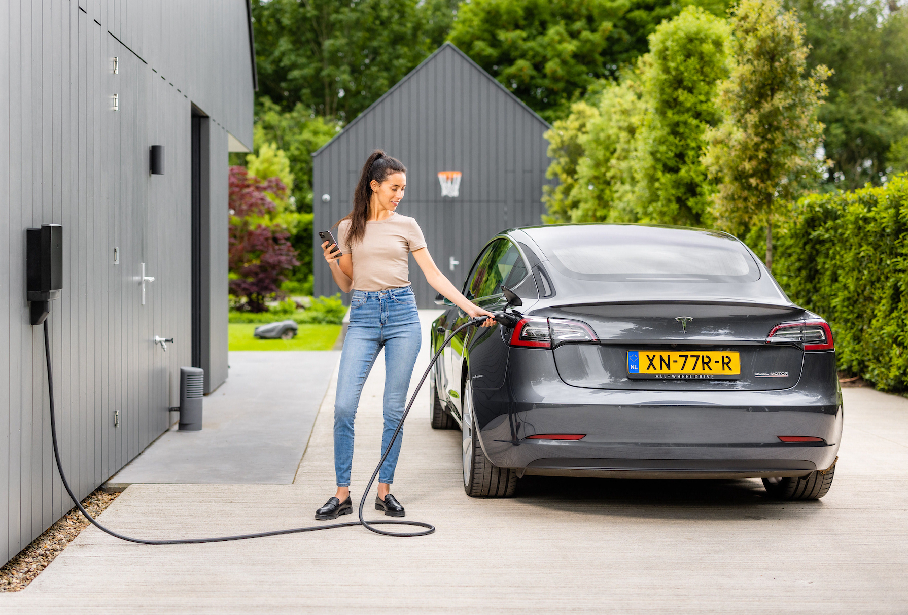 vrouw die elektrische auto slim laadt met de zonneplan laadpaal