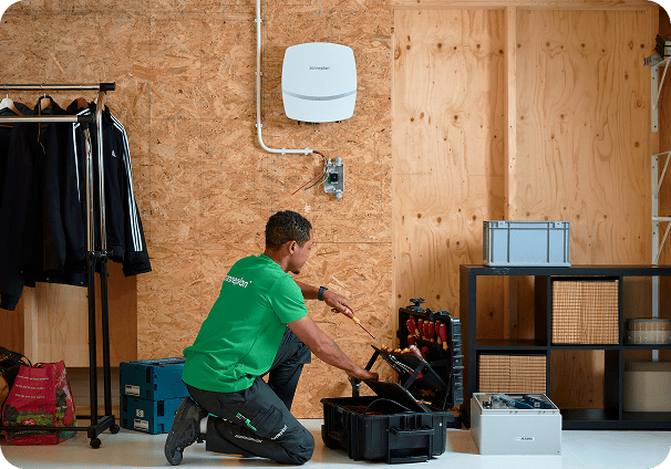 Monteur van Zonneplan die een omvormer installeert