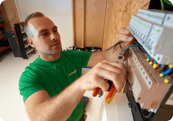 Zonneplan monteur werkt in de meterkast